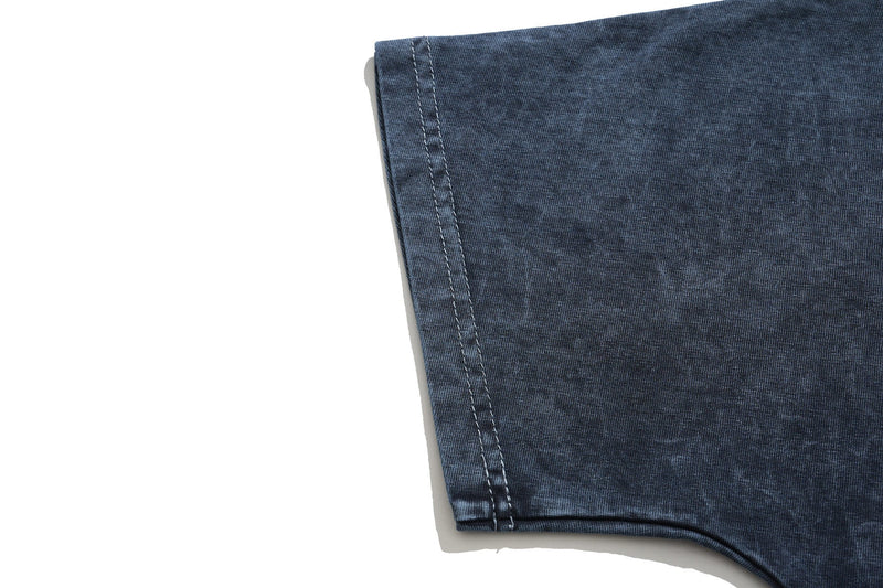 Close-up of a vintage washed dark blue gothic graphic T-shirt sleeve with visible double stitching and soft faded texture