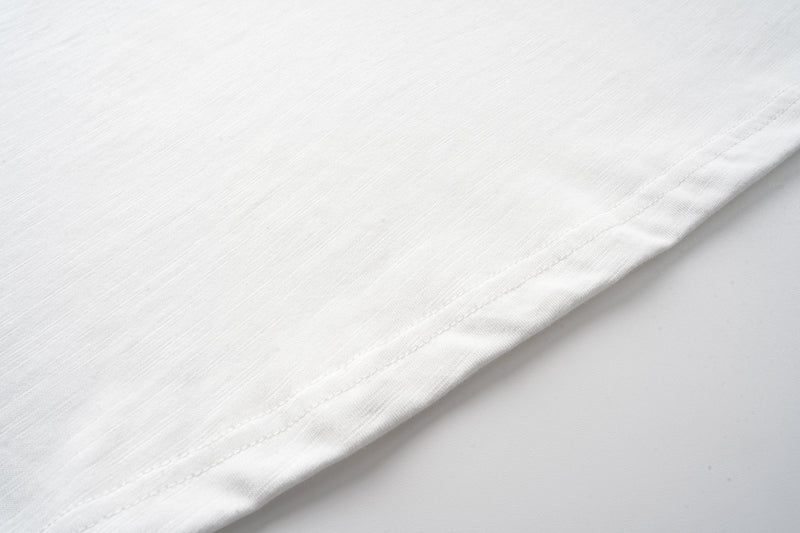 Close-up of smooth off-white sleeve fabric and stitched hem