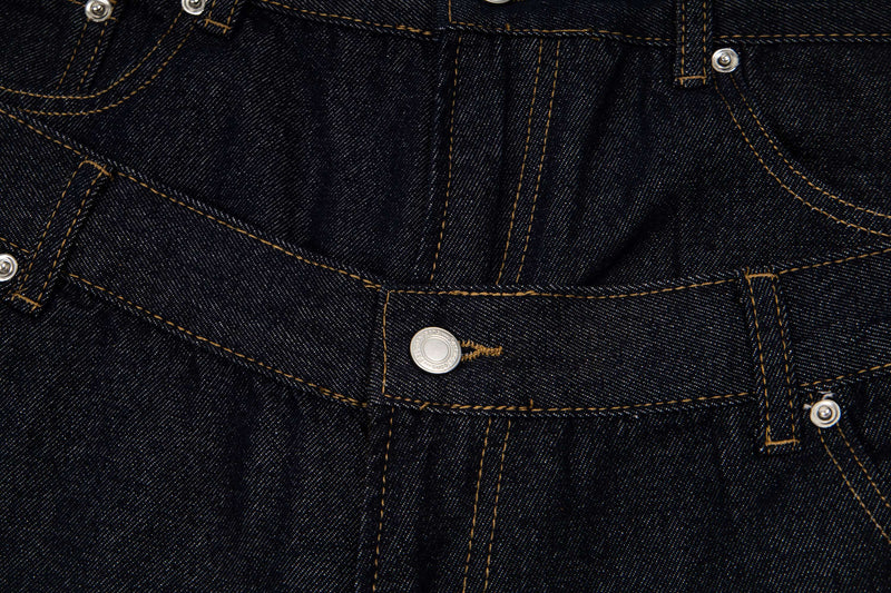 Close-up of front panel and snap details on dark wash denim shorts