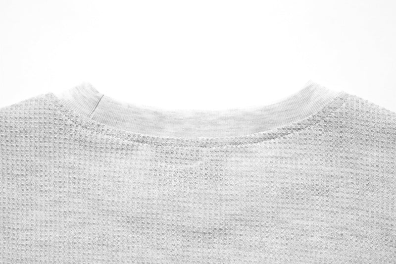 Close-up of white waffle-knit back neckline and shoulder seam
