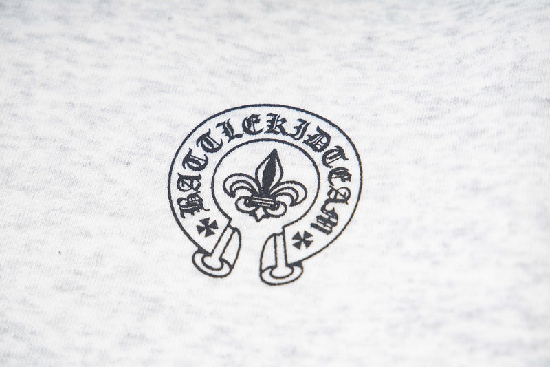 Close-up of white hoodie chest crest graphic with fleur-de-lis emblem and circular text