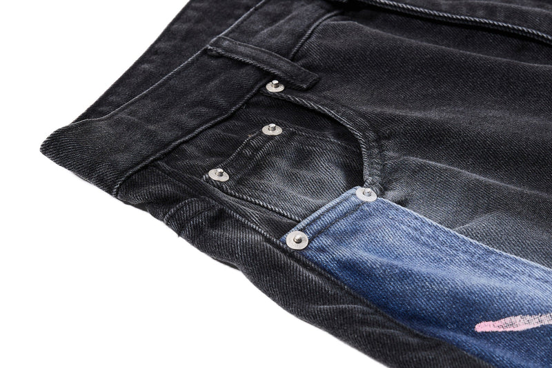 Close-up of side pocket area with black denim and blue graphic panel