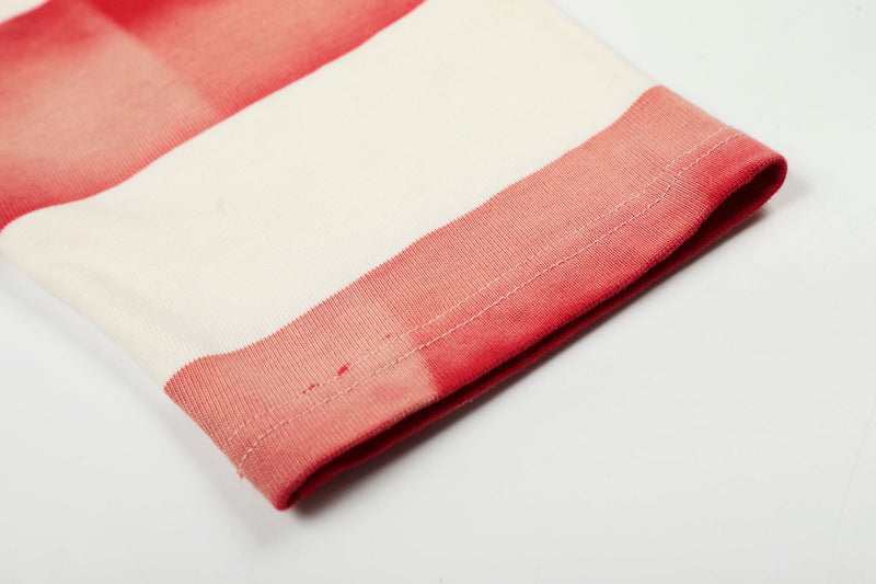 Close-up of hem on cream and red striped long sleeve rugby polo shirt