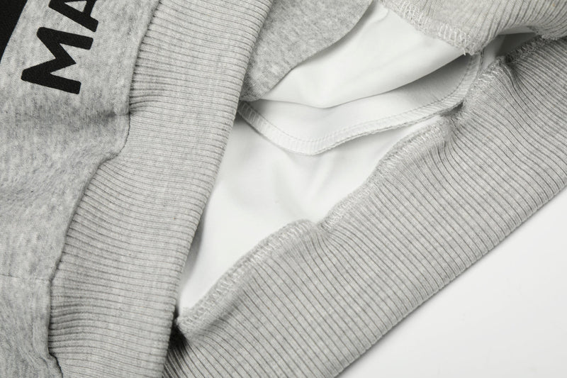 Close-up of light gray hoodie inside opening showing white lining and ribbed cuffs
