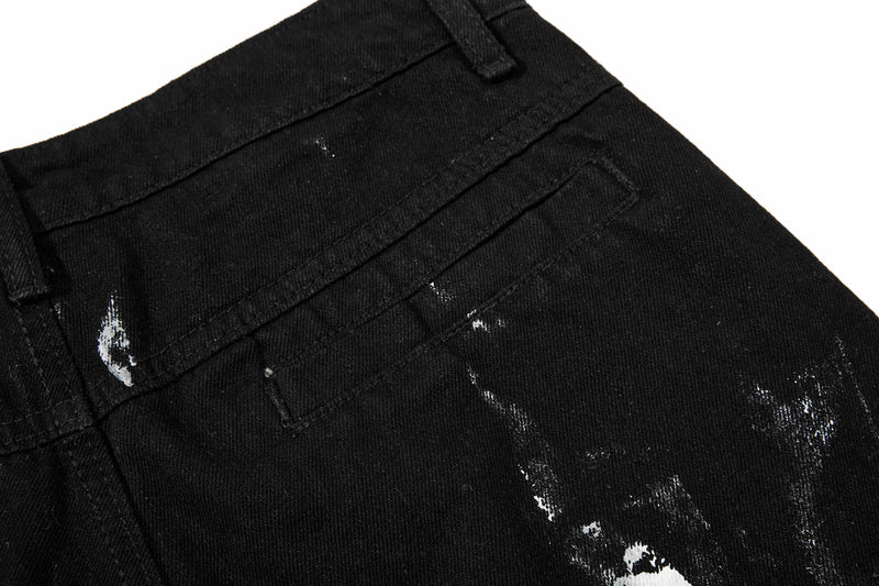 Back pocket area of black washed jeans with subtle distressed paint marks