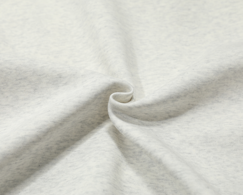 Close-up of heather gray fleece hoodie fabric texture and front pocket seam