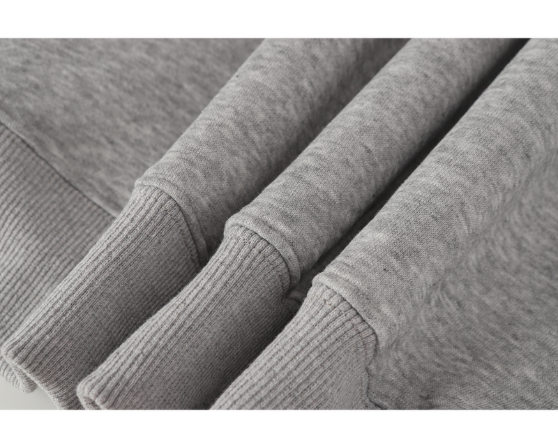 Close-up of ribbed sleeve cuffs and hem on light gray sweatshirt