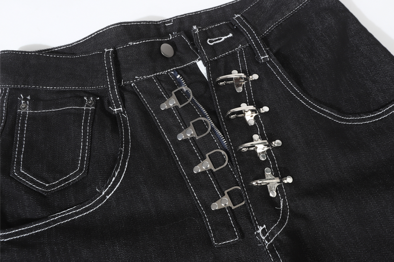 Close-up of black denim pants front waist with metal buckle closure and white topstitching