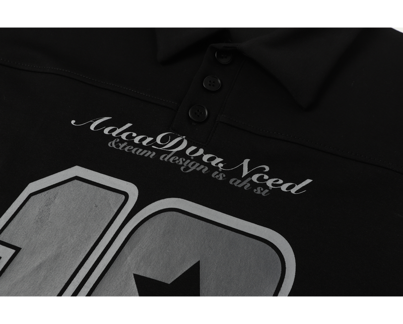 Close-up of front graphic and script text on black polo shirt