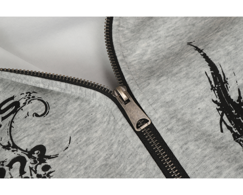 Close-up of light gray hoodie zipper with black teeth and gothic print near the chest
