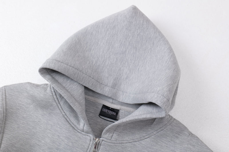 Close-up of light gray hoodie hood from the side showing smooth knit fabric