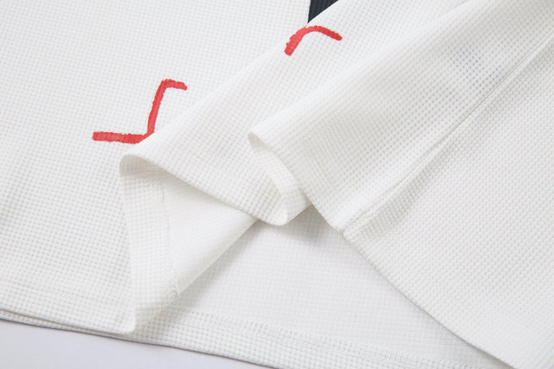 Folded white sleeve overlapping the printed shirt body with red lettering visible
