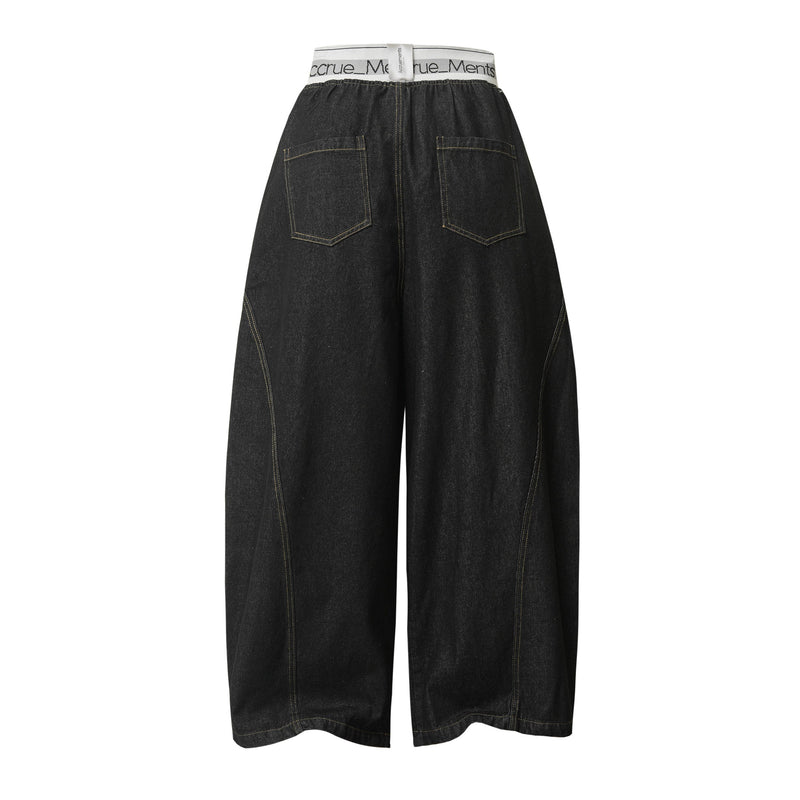 Back view of black wide-leg denim pants with elastic waist and patch pockets