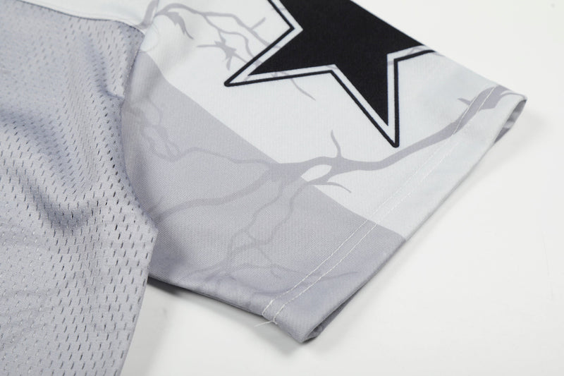 Close-up of a white mesh football jersey sleeve with black star graphic and subtle gray portrait print