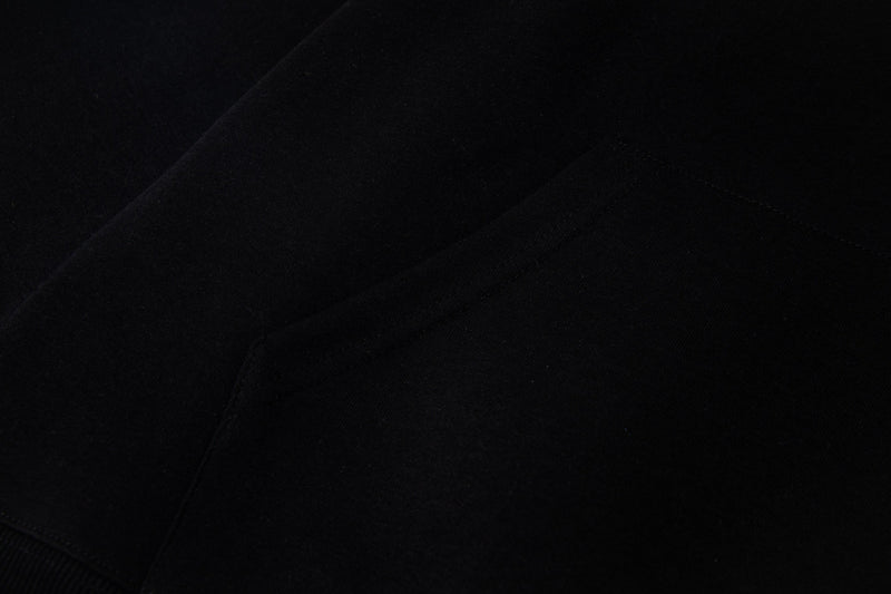 Close-up of black hoodie fabric with visible seam stitching and smooth texture