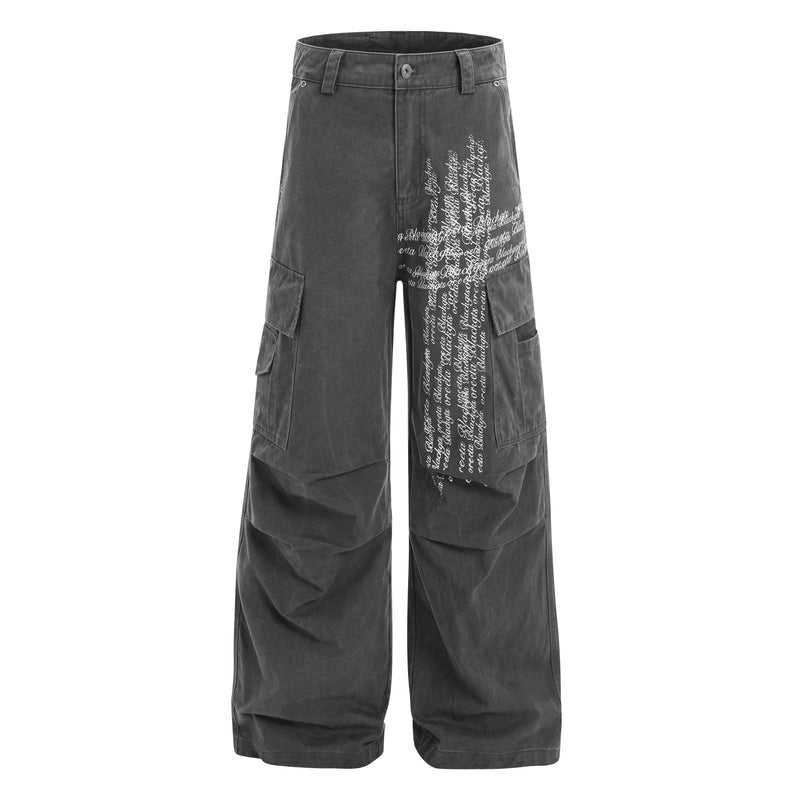 Front view of black cargo pants with large white cross script print on one leg