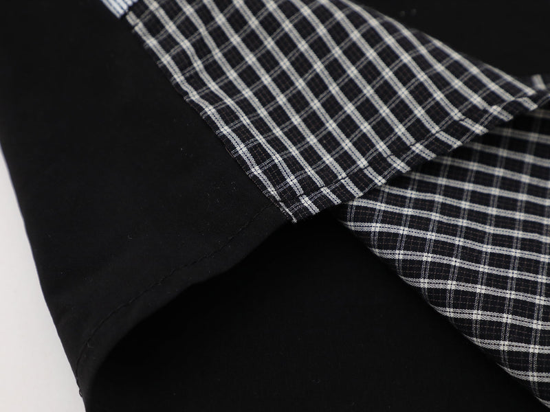 Close-up of a black plaid button-up shirt with white check pattern and contrast sleeve detail
