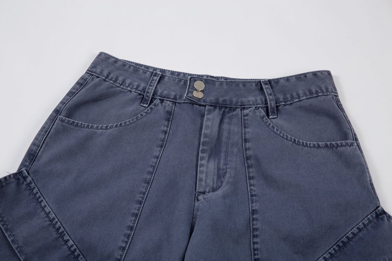 Close-up of blue denim waistband with double snap closure and front seam details