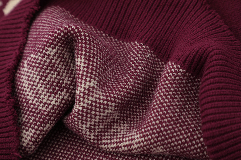 Close-up of burgundy and cream knit fabric texture on the sweater graphic