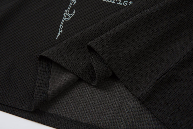 Close-up of layered black cuff and hem with matching textured fabric detail