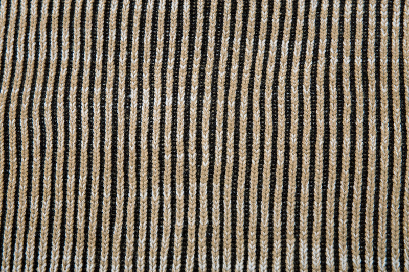 Close-up of the jacket's ribbed striped knit fabric with vertical beige, black, and white lines