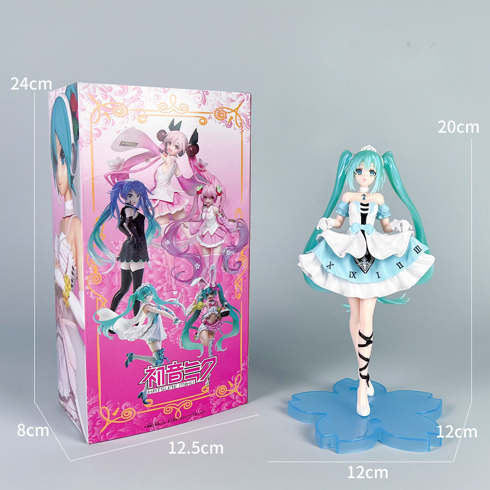 A photo displays the Hatsune Miku Cinderella Fairy Tale 20cm PVC Figure, featuring long turquoise hair and a white and black dress, on a blue base beside a colorful box measuring 24cm tall by 12.5cm wide. The figure stands at 20cm tall by 12cm wide.