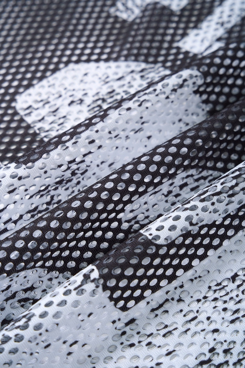 Close-up of black and white camo mesh jersey fabric with dotted texture and streetwear style