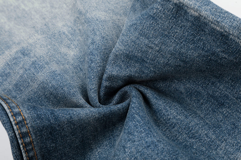 Close-up of soft faded blue denim fabric texture on baggy jeans