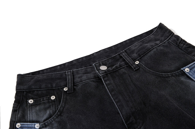 Angled close-up of black denim waist and front pocket rivets