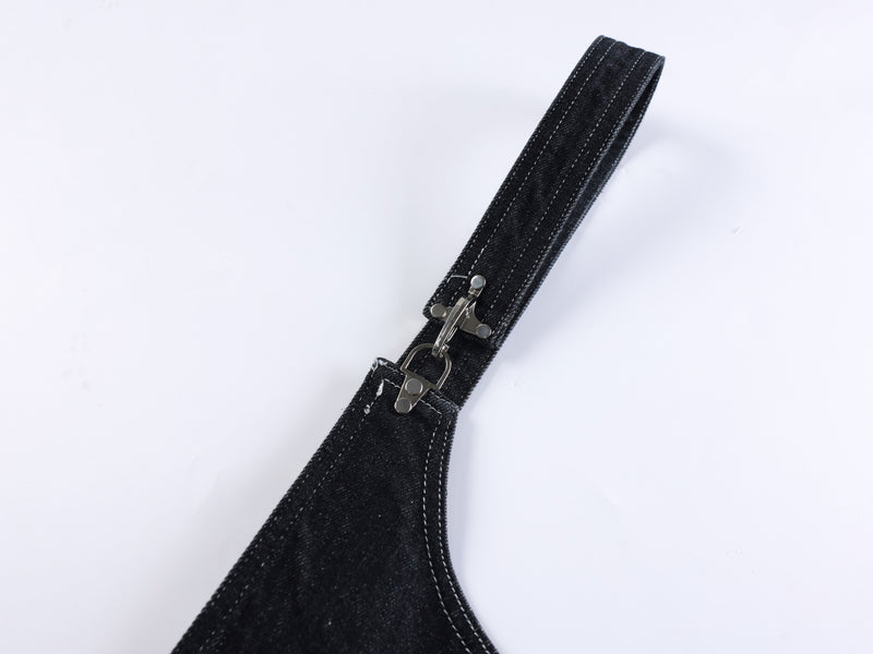 Close-up of black denim shoulder strap with metal buckle clasp