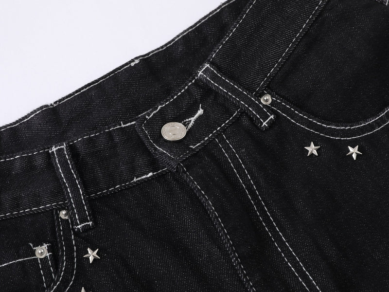 Close-up of black denim waistband and front button with star studs near the pocket