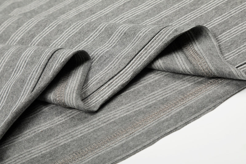 Stacked folds of gray striped long sleeve tee showing stitched seams and cuffs