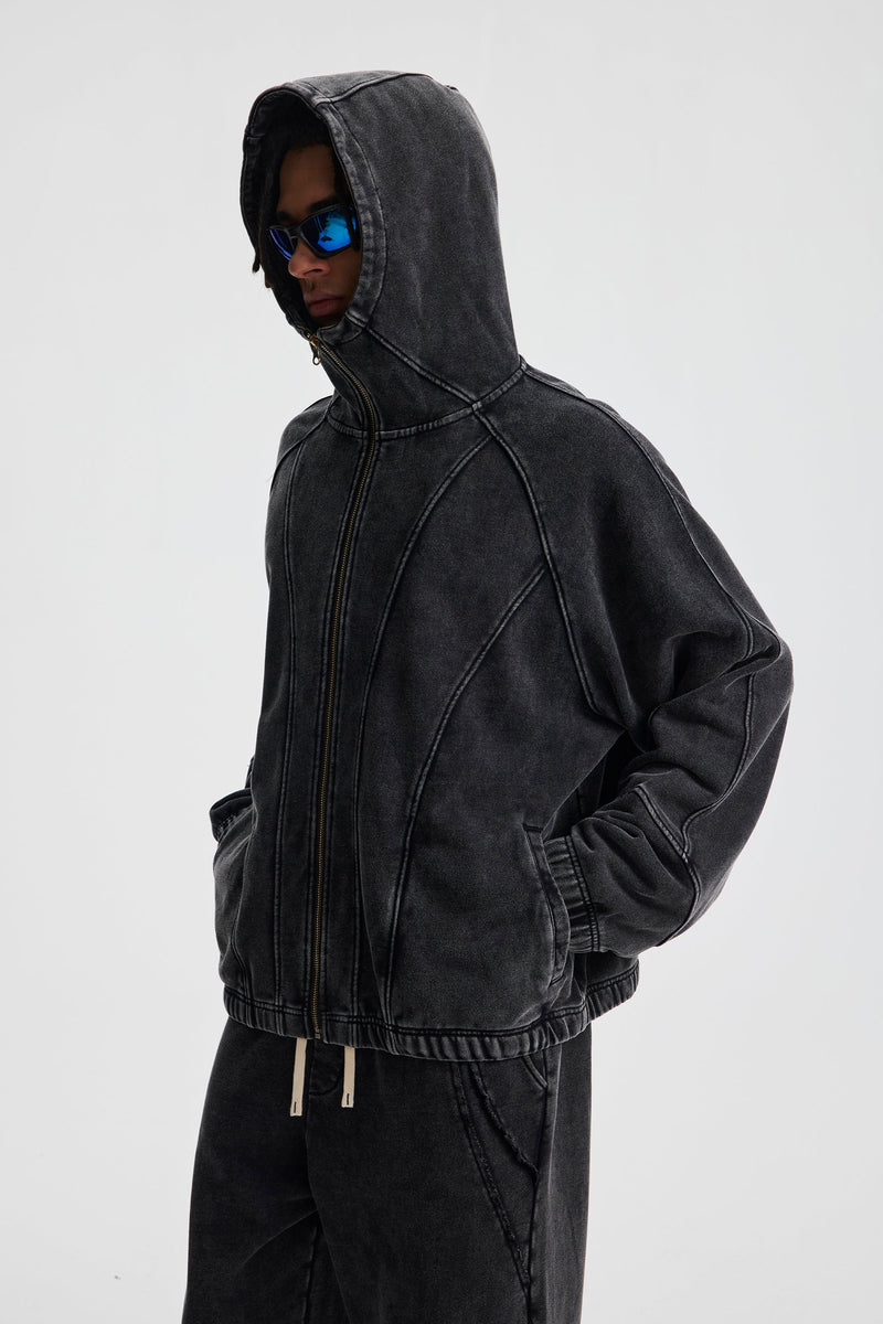 Three-quarter side view of black washed cotton hoodie with hood up and zip front