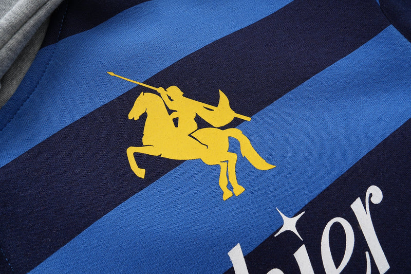 Close-up of yellow rider logo printed on blue and black striped hoodie