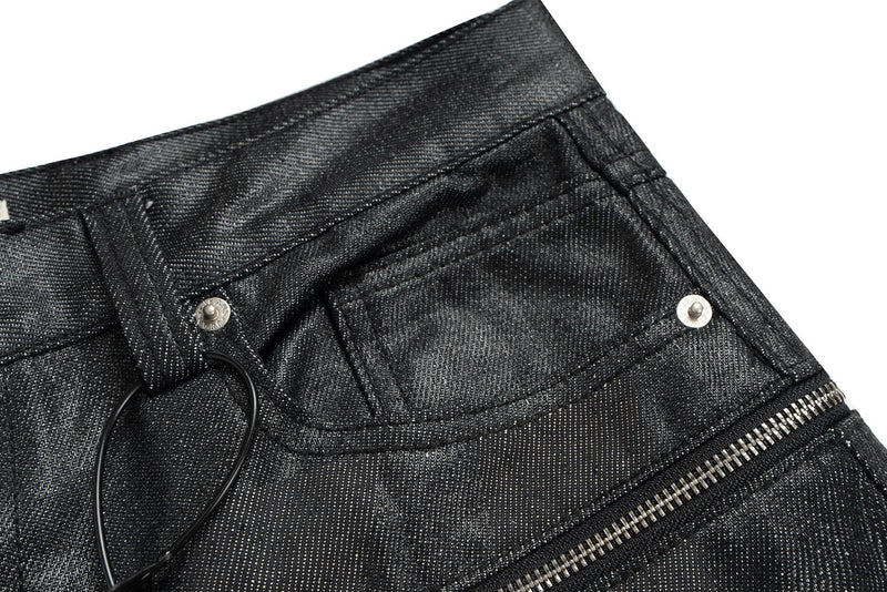 Close-up of black denim waistband and front pocket with ring detail
