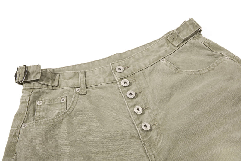 Close-up of olive green denim shorts front waist with button fly and pocket detail