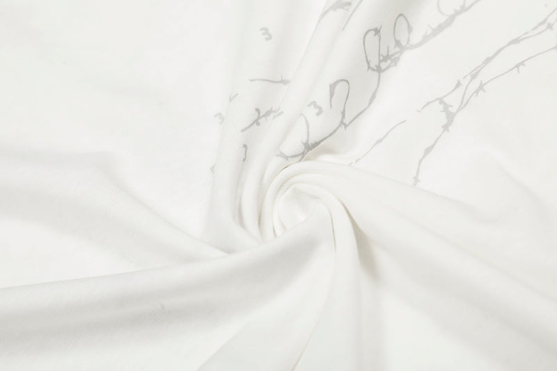 Close-up of white tee fabric gathered with faint gray graphic lines
