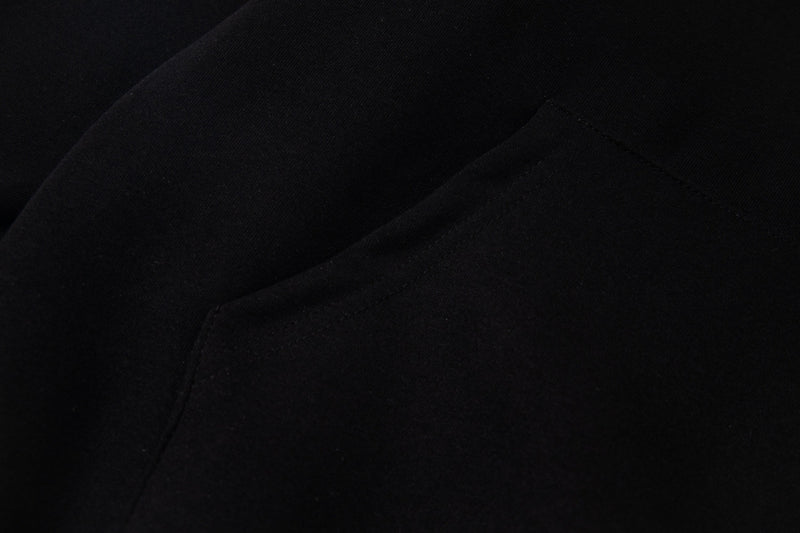 Black hoodie side seam close-up showing smooth fabric and stitching