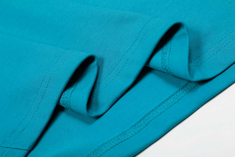 Close-up of a turquoise athletic T-shirt fabric with visible hem stitching and folded sleeve detail