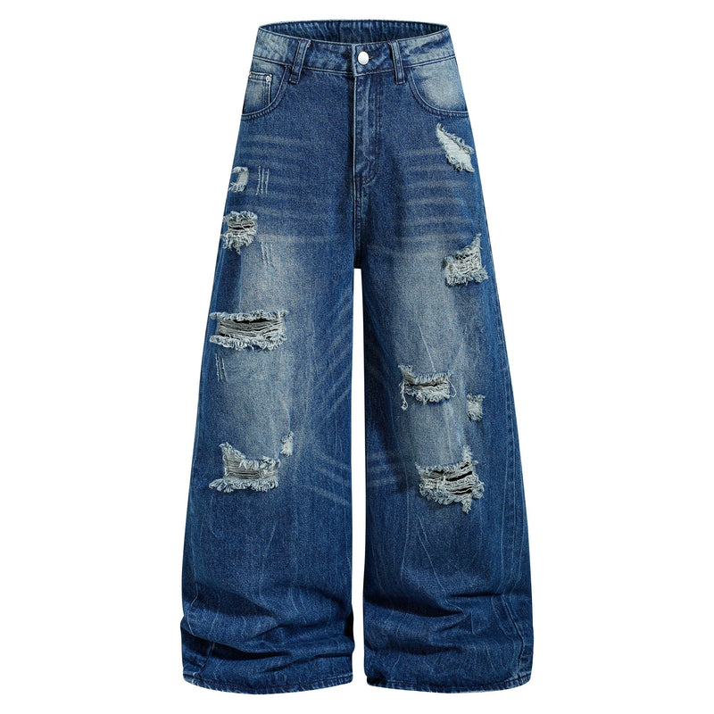 Front view of wide-leg distressed blue jeans with ripped patches and faded wash