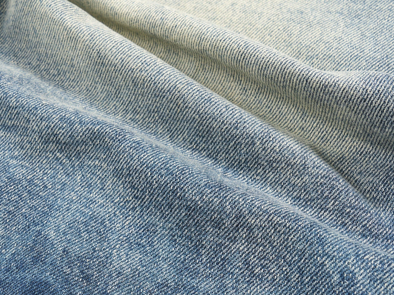 Close-up of denim fabric texture with light and dark faded wash
