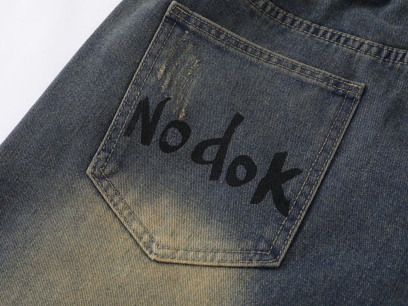 Close-up of back pocket with printed text and faded blue denim texture
