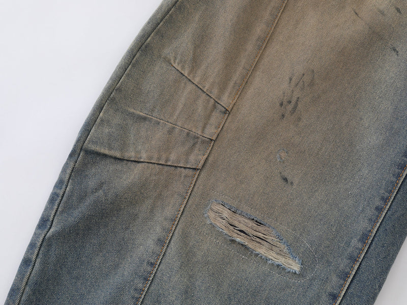Close-up of leg panel seam and distressed patch on vintage wash denim