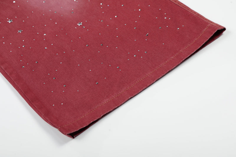 Lower leg hem of red wide-leg jeans with scattered rhinestone stars