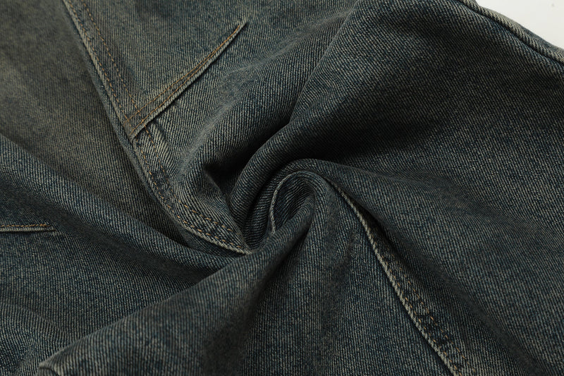 Close-up of gathered dark wash denim fabric showing texture and seam stitching
