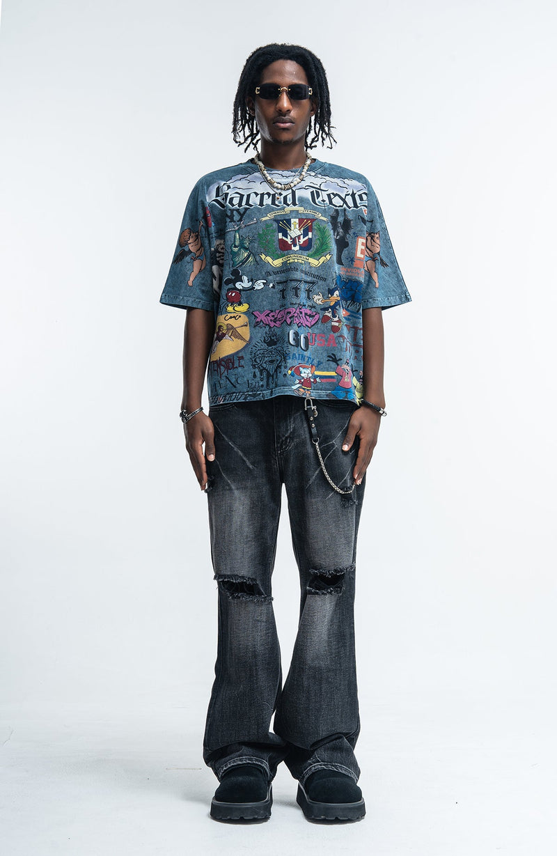 Vintage wash graphic tee with Sacred Chaos print, worn with distressed black jeans and sunglasses on a model