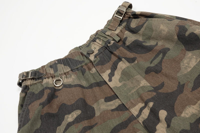 Close-up of elastic waistband and metal ring detail on green brown camouflage shorts