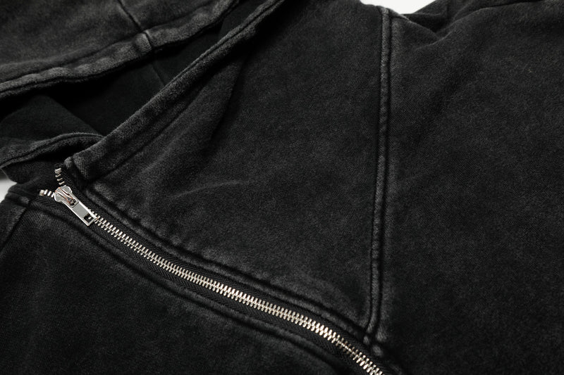 Close-up of black hoodie jacket chest seam and silver diagonal zipper