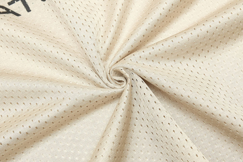 Close-up of beige mesh jersey fabric with perforated texture, showing the Starline streetwear material design