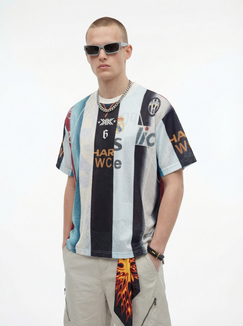 Model wearing a vintage patchwork mesh football jersey with graphic panels, layered chain necklace, and sunglasses